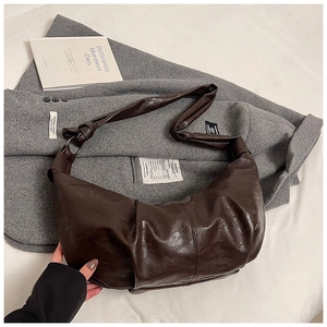 Detailed close-up of dark brown soft leather hobo bag with vintage pleated texture