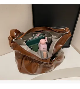 Draufsicht auf braune Falten-Schultertasche mit geräumigem Innenraum für Alltagsgegenstände
