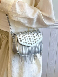 Silver studded square crossbody bag with metallic tassels and chain strap on model