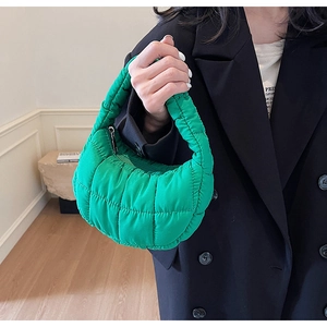 Close-up of vibrant green puffer cloud bag featuring quilted nylon texture and silver zipper