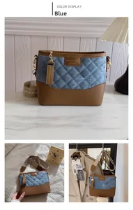 Close-up of blue denim and brown leather quilted bucket bag with a stylish wide strap