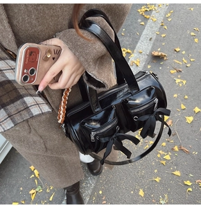 Détail du sac cylindrique noir style ballet avec nœuds sur une rue d'automne