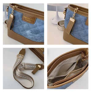 Detail view of denim bucket bag showing leather logo, metal hardware and inner pockets