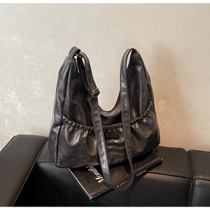 Detailaufnahme der Vintage-Hobo-Tasche mit Falten in Dunkelgrau und glänzender Textur