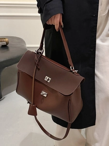 Brown leather tote bag with silver twist lock and shoulder strap for elegant commuting