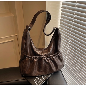 Detaillierte Nahaufnahme einer dunkelbraunen Vintage Leder Hobo Tasche mit Falten-Design