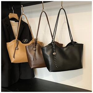 Three minimalist tote bags in beige, brown, and black hanging with elegant metal bead charms