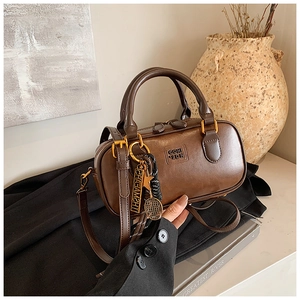 Detail of vintage brown Boston bag with CQHI 2DN logo and gold tennis racket charms