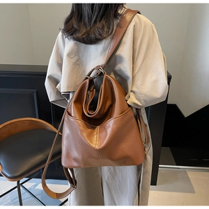 Gros plan du sac cabas en cuir marron grainé montrant la poche latérale et la bandoulière
