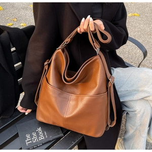 Détail de la texture en similicuir marron et grande poche avant du sac cabas d'épaule