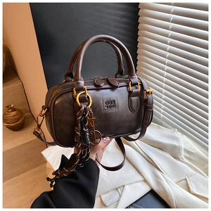 Detailed close-up of dark brown vintage Boston bag with gold hardware and logo engraving