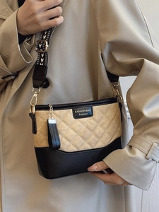 Chic quilted canvas bucket bag with black leather trim and wide geometric woven strap