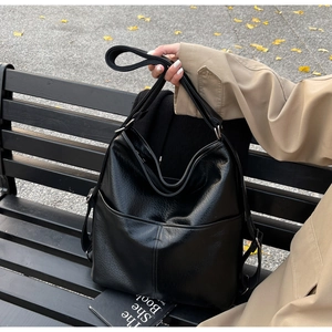Vue détaillée du sac cabas en cuir souple noir avec des poches frontales pratiques