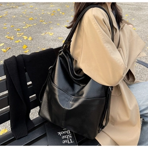 Détail du grand sac cabas en cuir noir avec texture grainée et bandoulière réglable