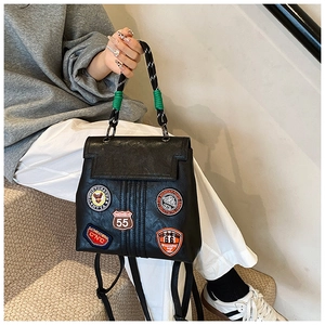 Detail view of black faux leather backpack with colorful embroidery and rope handle