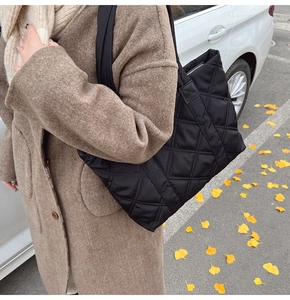 Dettaglio borsa shopper trapuntata in nylon nero con cerniera e tracolla larga
