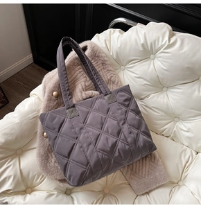 Dettaglio della trama trapuntata a rombi su una borsa tote in nylon grigio viola