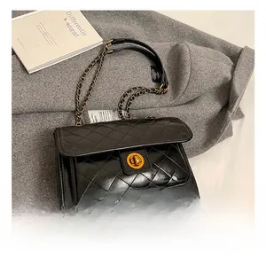 Detail of black quilted leather shoulder bag with gold twist lock and chain strap
