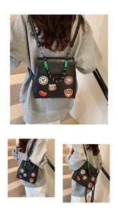 Detail view of retro black PU leather backpack with colorful vintage embroidered patches