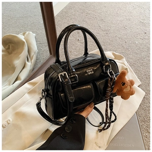 Détail du sac bowling en cuir verni noir avec garniture argentée et pendentif ours