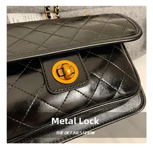 Detail of classic black quilted leather bag showing gold rotating metal lock and stitching