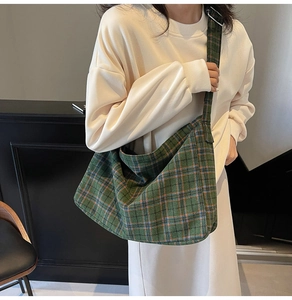 Macro shot of large green plaid canvas tote bag with wide strap for daily casual style