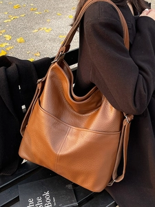 Sac cabas en cuir marron avec poches avant et bandoulière réglable sur mannequin femme