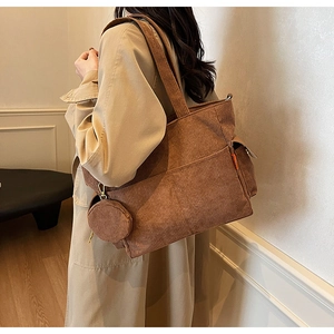 Detailed texture of brown corduroy tote bag with small round coin purse and orange label