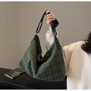 Detail shot of green blue plaid tote bag showing soft textured fabric and metal buckle