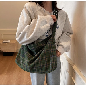 Detail of tartan canvas tote bag with adjustable wide strap and silver metal buckle