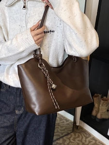 Vintage brown leather tote bag with knot handles and metallic ball charm accessory