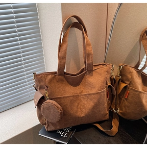 Detail of brown corduroy tote bag showing side pocket and matching round coin purse