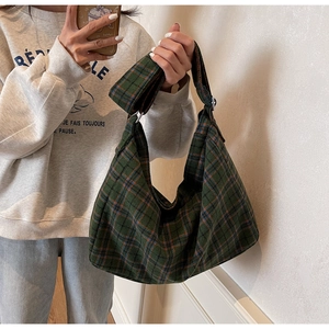 Detail shot of the green plaid pattern and wide canvas strap on the casual tote bag