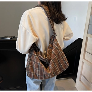 Brown plaid Hobo bag with adjustable shoulder strap shown on model for daily commute