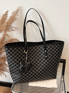 Minimalist black tote bag with white monogram pattern and dual shoulder straps