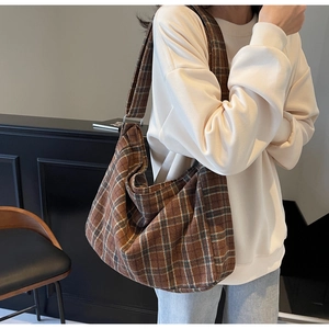 Close-up of vintage brown plaid tote bag with thick canvas texture and metal buckle