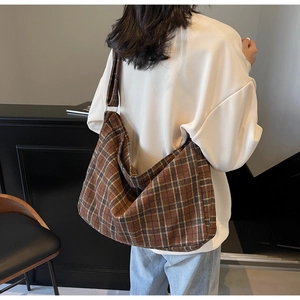 Brown plaid hobo bag worn by model showing large capacity and vintage canvas texture