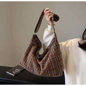 Detail of checkered brown hobo tote bag showing textured fabric and metal buckle