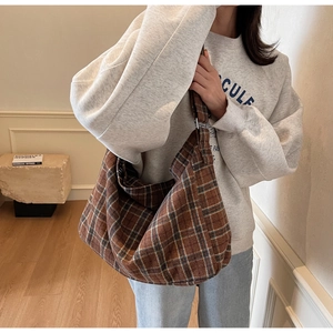 Detail of large brown plaid hobo bag featuring soft texture for daily commute or campus style