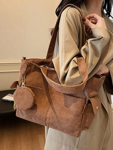 Large brown corduroy tote bag with side pocket and matching coin purse on model