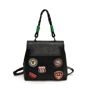 Detail view of black PU leather backpack with vintage embroidery badges and rope handle