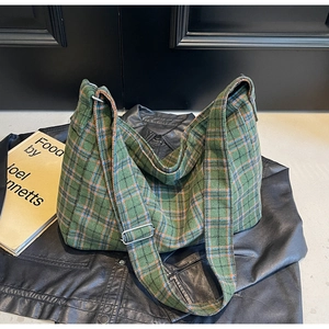 Detail of adjustable strap and classic green plaid fabric on a large capacity tote bag