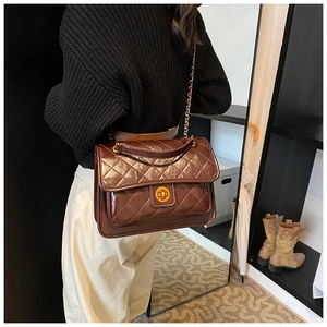 Close-up of brown quilted faux leather bag with gold chain strap and metal rotary lock