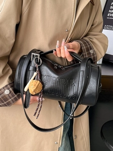 Minimalist black cylinder shoulder bag in premium leather with a cute bear charm