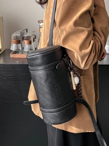 Vintage black cylinder leather shoulder bag with embossed lettering and baseball charm