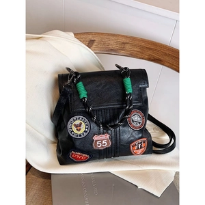 Retro black leather backpack with embroidered badges and green woven handle
