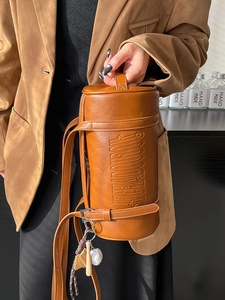 Brown retro leather cylinder bag with embossed stars and creative baseball pendant