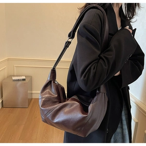 Dettaglio della morbida pelle vintage marrone scuro e della zip in metallo della borsa