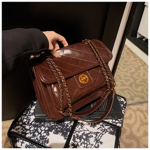 Detail of quilted brown chain bag featuring a glossy PU finish and gold rotating lock