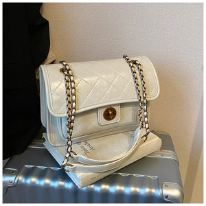 Detail of white quilted leather shoulder bag with gold twist lock and chain strap